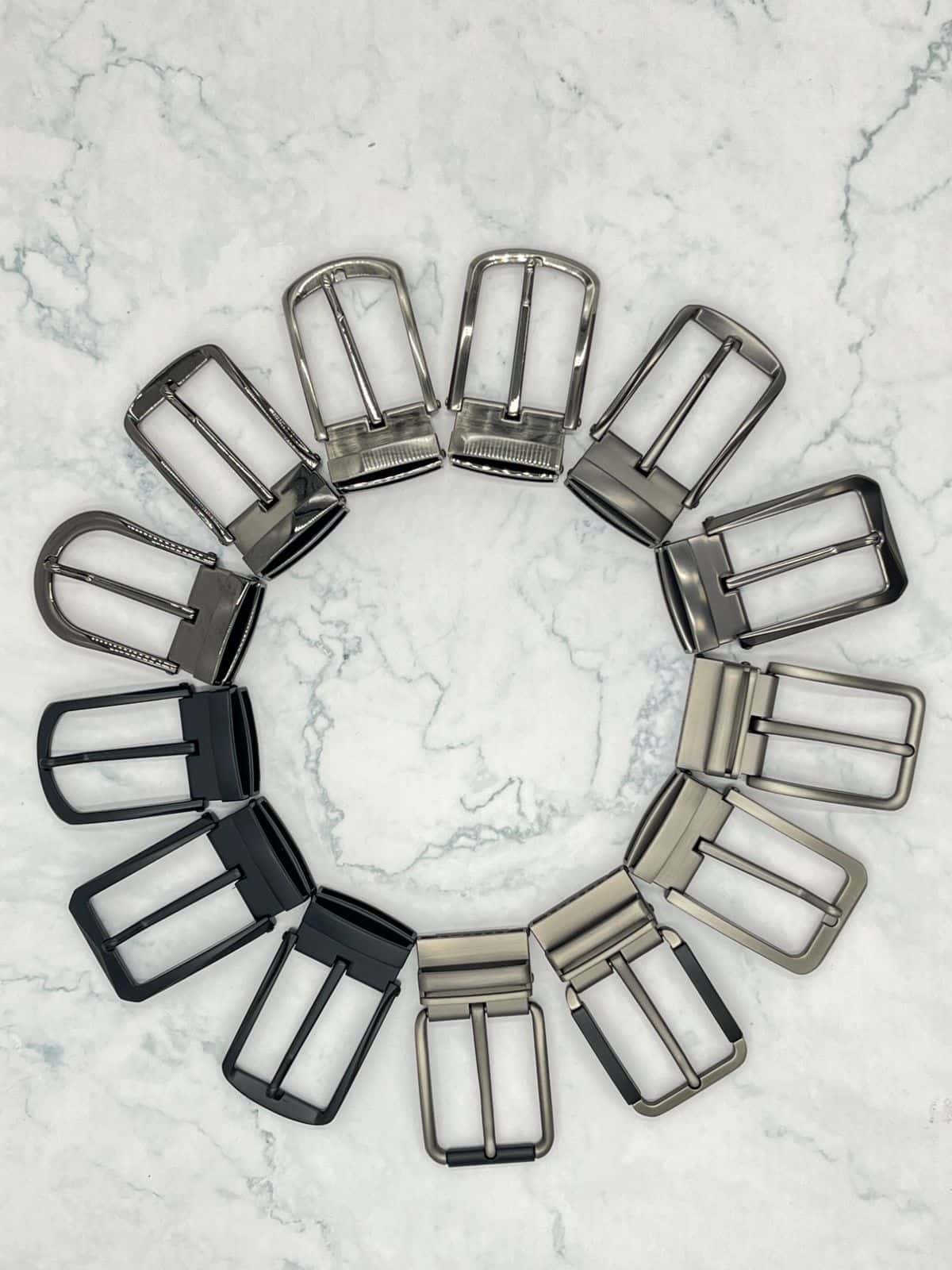 Fourteen pin buckles in a circle — polished, brushed gunmetal, satin nickel and matte black